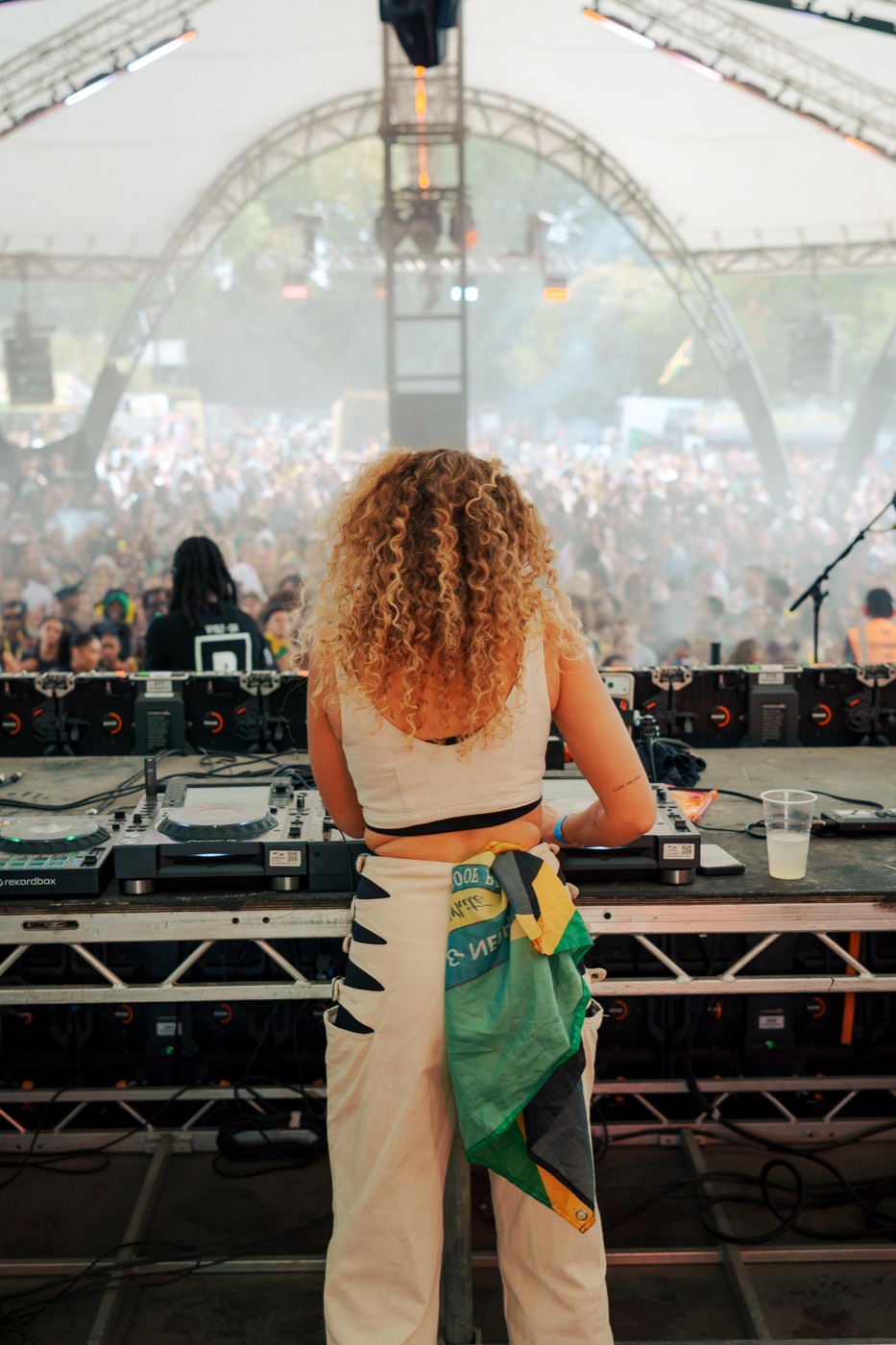 Becca D on stage facing a huge festival crowd